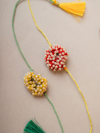 Beaded Coral Crochet Rakhi (Set Of 2)